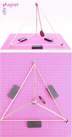 the model is made out of sticks and other items on a pink tablecloth with white squares