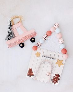 two small wooden toys sitting next to each other on a white surface with pink and blue decorations