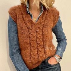 a woman wearing a brown sweater vest and jeans