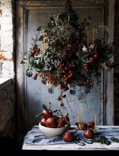 an arrangement of fruit is displayed on a table in front of a door and window