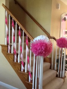 pink and white pom poms are on the banisters