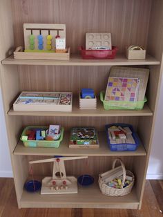 a wooden shelf filled with toys on top of a hard wood floor