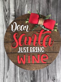 a wooden sign that says dear santa just bring wine with a red bow on it