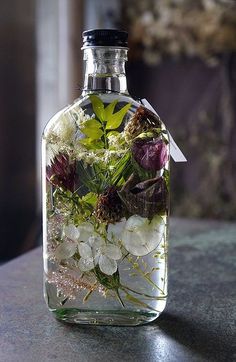 a glass bottle filled with flowers on top of a table