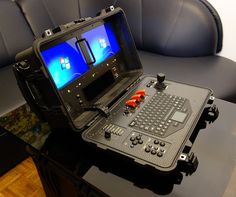 an open laptop computer sitting on top of a table in front of a black chair