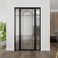 an empty room with wooden floors and black glass doors that lead into the dining area