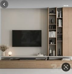 a flat screen tv sitting on top of a wooden entertainment center next to a book shelf