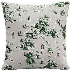 a green and white pillow with snow skiers on the mountain in front of it