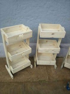 three wooden crates sitting next to each other on the ground in front of a wall