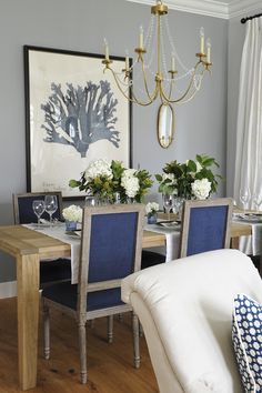 a dining room table with blue chairs and a chandelier