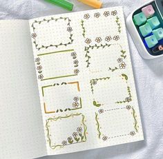 an open notebook with flowers on it next to crayon markers and pencils