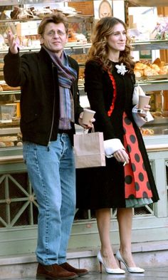 a man and woman standing next to each other in front of a bakery display case