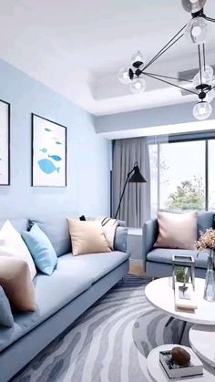 a living room filled with blue couches next to a white table and chair in front of a window