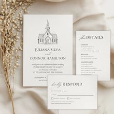 the wedding stationery is laid out on a white cloth with dried flowers in front