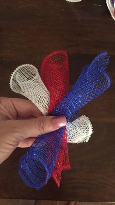 someone is holding three pieces of red, white and blue mesh