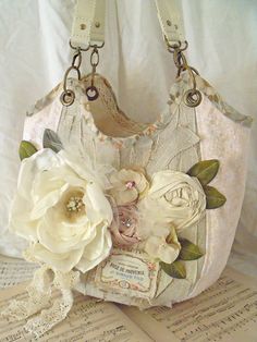 a purse with flowers on it sitting on top of an open book