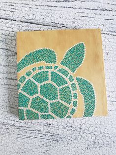 a wooden block with a green turtle on it's back and the words sea life painted on it