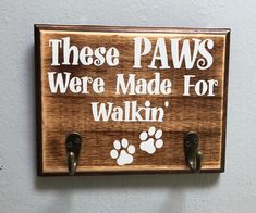 a wooden sign that says, these paws were made for walkin '