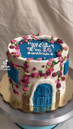 a birthday cake decorated with flowers and an arch