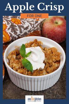 an apple crisp in a white bowl with whipped cream on top