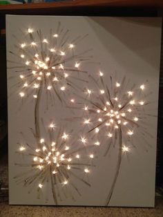 a white canvas with some lights on it in the shape of a dandelion