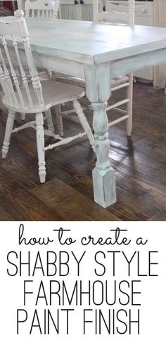 a white table and chairs in a room with hardwood floors, cabinets and an island