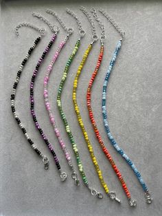 six different colors of beads on a silver chain