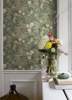 a vase filled with flowers sitting on top of a white table next to a window