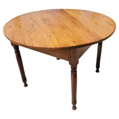 an old wooden table with two legs and a round top on it's side