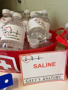 some bottles of water are sitting on a table with a sign that says saline grey's anatomy