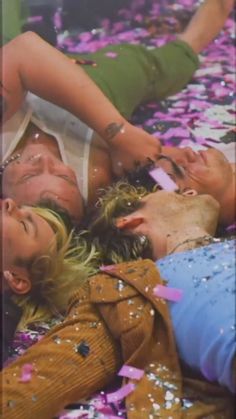 three women laying on the ground surrounded by confetti