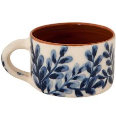 a blue and white coffee cup with leaves on it