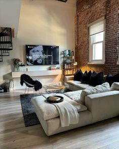 a living room filled with furniture and a flat screen tv mounted to the side of a wall