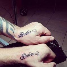 two people with matching tattoos on their arms holding each other's hands and the words brother and sister written in cursive font