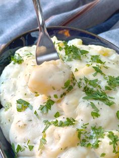 a bowl filled with mashed potatoes and garnished with parsley