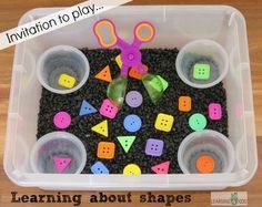 a plastic container filled with lots of different colored buttons and scissors on top of it