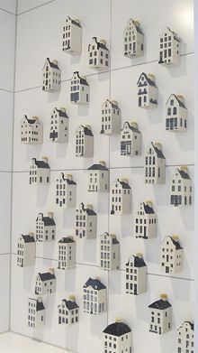 a wall that has some houses on it and is decorated with paper cutouts in the shape of houses