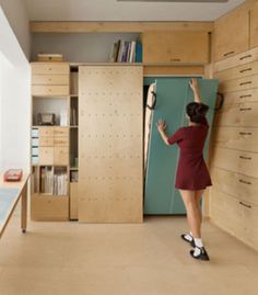 a woman standing in front of a refrigerator freezer next to a book shelf filled with books