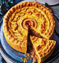 a pie on a blue plate with one slice cut out and the rest half eaten