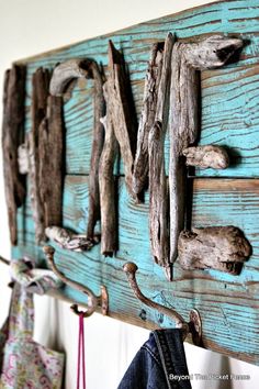 a coat rack made out of driftwood is hanging on the wall