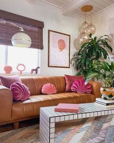 a living room filled with lots of furniture next to a fire place and potted plants