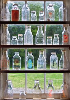 many bottles are lined up on the window sill