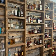 shelves filled with lots of different types of liquors on wooden pallet walls in a store