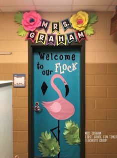 a door decorated with flowers and a pink flamingo