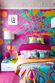 a bedroom with bright colored walls and colorful bedding in the center is a brightly colored headboard