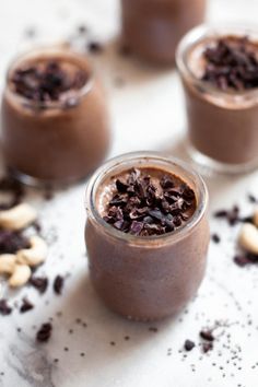 three glasses filled with chocolate pudding and nuts