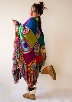 a woman is wearing a multicolored shawl with fringes on her shoulders