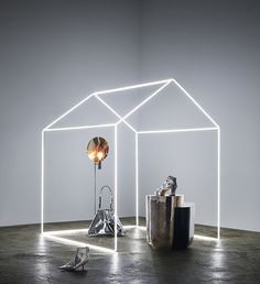 an illuminated room with various objects on the floor, including a lamp and a sculpture