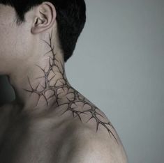 a man's neck is adorned with barbed wire