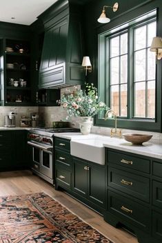 a kitchen with dark green cabinets and white counter tops, an area rug on the floor